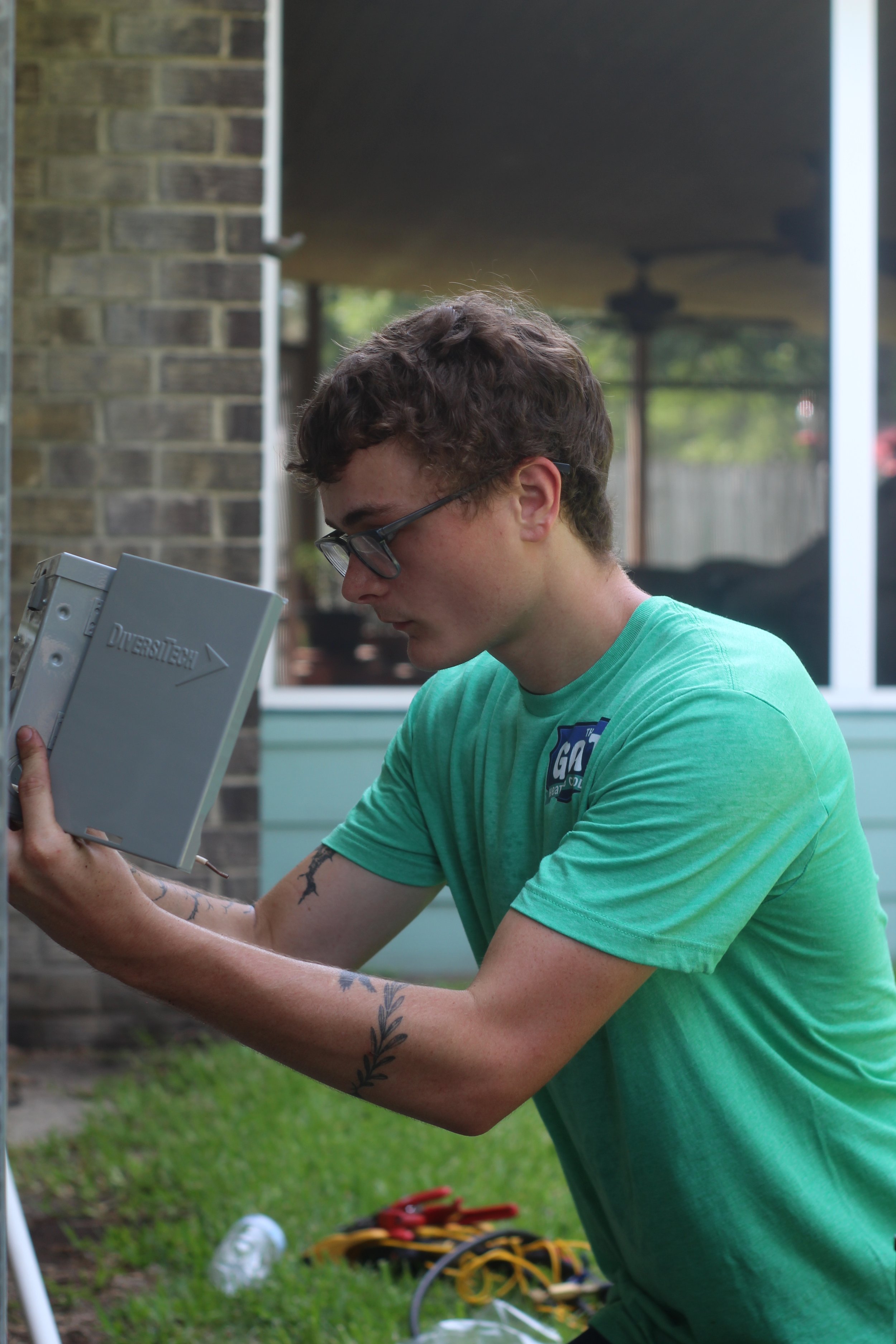 A Goat technician inspecting an outdoor electrical component