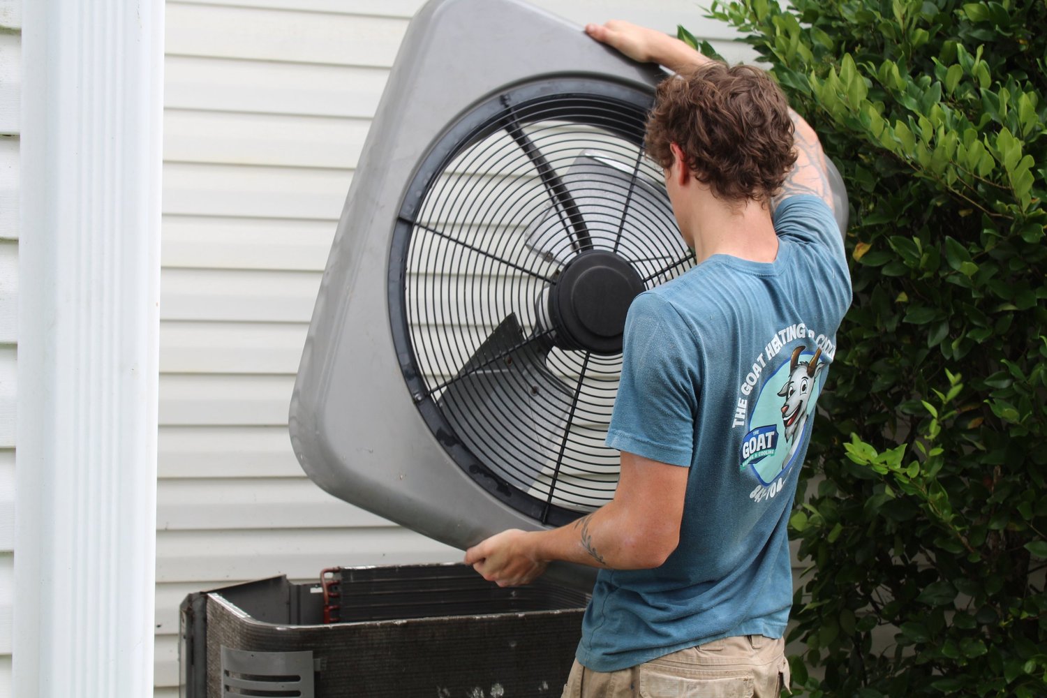 A Goat technician servicing an outdoor air conditioning system